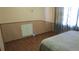 Inviting bedroom features wood flooring, wainscoting, and light-colored walls at 3083 55Th N Ave, St Petersburg, FL 33714
