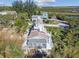 Wide aerial view of a quaint gray home with white accents and a rooftop deck surrounded by lush vegetation at 3476 Tidewater Dr, Weeki Wachee, FL 34607