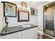 Charming bathroom featuring black tile countertop, nautical decor, and a glass-enclosed shower stall at 3476 Tidewater Dr, Weeki Wachee, FL 34607