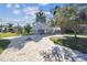 Charming stilt home featuring a brick driveway, large deck, and tropical landscaping at 3476 Tidewater Dr, Weeki Wachee, FL 34607