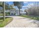 Charming stilt home featuring a brick driveway, large deck, and tropical landscaping at 3476 Tidewater Dr, Weeki Wachee, FL 34607
