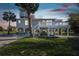 Charming stilt home featuring a large deck, lush greenery, and tropical landscaping at 3476 Tidewater Dr, Weeki Wachee, FL 34607
