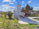 View of an elevated home featuring a paver driveway, lush lawn, and a viewing tower at 3476 Tidewater Dr, Weeki Wachee, FL 34607