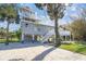 Exterior view of a gray home on stilts featuring a white deck and mature landscaping at 3476 Tidewater Dr, Weeki Wachee, FL 34607
