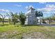 Charming stilt home featuring a large deck, lush greenery, and tropical landscaping at 3476 Tidewater Dr, Weeki Wachee, FL 34607