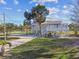 An elevated home displays its covered porch, lush front lawn and a paver driveway at 3476 Tidewater Dr, Weeki Wachee, FL 34607