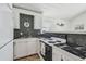 Charming kitchen with white cabinets and contrasting black countertops at 3476 Tidewater Dr, Weeki Wachee, FL 34607