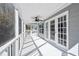 White screened porch with ceiling fan and white railings offer views of greenery and neighborhood at 3476 Tidewater Dr, Weeki Wachee, FL 34607