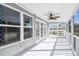 Outdoor screened porch with ceiling fan and white railings offers views of greenery and neighborhood at 3476 Tidewater Dr, Weeki Wachee, FL 34607