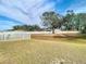 Large backyard with a white fence and mature trees at 37804 Prairie Rose Loop, Zephyrhills, FL 33542