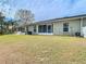Home exterior showcasing a screened porch and grassy backyard at 37804 Prairie Rose Loop, Zephyrhills, FL 33542