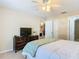Bedroom with a double bed, TV, dresser, and access to a walk-in closet at 37804 Prairie Rose Loop, Zephyrhills, FL 33542