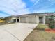 Front view of a three-unit building, with driveway and landscaping at 37804 Prairie Rose Loop, Zephyrhills, FL 33542