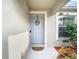 Light gray front door with welcome sign and landscaping at 37804 Prairie Rose Loop, Zephyrhills, FL 33542