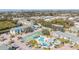 An aerial view of a condo complex featuring a pool and tennis court amidst lush foliage and parking at 455 Alt 19 S # 268, Palm Harbor, FL 34683