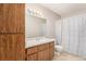 This bathroom features wooden cabinets, a large mirror, and a shower with a floral shower curtain at 455 Alt 19 S # 268, Palm Harbor, FL 34683