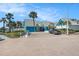 Exterior of the community clubhouse with blue accents, lush landscaping, and ample parking at 455 Alt 19 S # 268, Palm Harbor, FL 34683