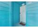 A charming turquoise condo entrance featuring a white door with the number 268 at 455 Alt 19 S # 268, Palm Harbor, FL 34683