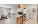 Practical kitchen with wood cabinets, essential appliances, and an adjacent dining and living space at 455 Alt 19 S # 268, Palm Harbor, FL 34683