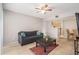 This living room features tile floors, a black couch, and a view of the kitchen and dining area at 455 Alt 19 S # 268, Palm Harbor, FL 34683