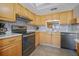 Kitchen with wood cabinets, granite countertops, and stainless steel appliances at 460 Paula S Dr # 401, Dunedin, FL 34698