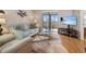 Living room with comfy seating, large TV, and access to balcony at 460 Paula S Dr # 401, Dunedin, FL 34698