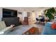 Open living space with mid-century modern furniture and a large TV at 4900 Brittany S Dr # 909, St Petersburg, FL 33715