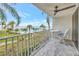 Balcony with table and chairs overlooking the water and community pool surrounded by palm trees at 5155 S Isla Key S Blvd # 202, St Petersburg, FL 33715
