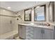 Modern bathroom featuring double sinks, granite countertops, and a glass-enclosed shower at 5155 S Isla Key S Blvd # 202, St Petersburg, FL 33715