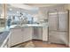 Bright kitchen with stainless steel appliances, white cabinetry, and breakfast bar overlooking the living space at 5155 S Isla Key S Blvd # 202, St Petersburg, FL 33715