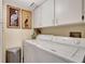 Functional laundry room with washer, dryer, and overhead storage cabinets at 5155 S Isla Key S Blvd # 202, St Petersburg, FL 33715