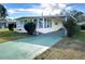 Front view of a yellow single-story home with a carport at 6021 Ridgewood Dr, Zephyrhills, FL 33542