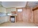 Kitchen with outdated appliances and wood paneling at 6021 Ridgewood Dr, Zephyrhills, FL 33542