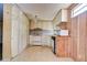 View of kitchen with white cabinets and wood paneling at 6021 Ridgewood Dr, Zephyrhills, FL 33542