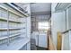 Laundry room with washer, dryer, and ample shelving at 6021 Ridgewood Dr, Zephyrhills, FL 33542
