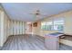 Living room with ceiling fan, wood paneling, and vinyl flooring at 6021 Ridgewood Dr, Zephyrhills, FL 33542