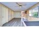 Living room boasts wood paneling, vinyl flooring, and a ceiling fan at 6021 Ridgewood Dr, Zephyrhills, FL 33542