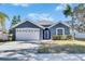 Gray house with white garage door, landscaping, and a walkway at 10322 Goldenbrook Way, Tampa, FL 33647