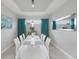 Elegant dining room featuring a white table and teal curtains at 11111 Callisia Dr, Odessa, FL 33556