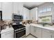 Modern kitchen with white cabinets and stainless steel appliances at 11111 Callisia Dr, Odessa, FL 33556