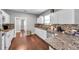 Kitchen boasts white cabinets, granite counters, and tile backsplash at 1318 E Louise Ave, Tampa, FL 33603