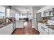 Open kitchen with white cabinets, granite counters, and hardwood floors at 1318 E Louise Ave, Tampa, FL 33603