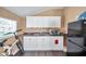 Small galley kitchen with white cabinets and black appliances at 1318 E Louise Ave, Tampa, FL 33603