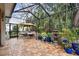 Spacious screened patio features a seating area and lush tropical landscaping at 23 Concord Dr, Dunedin, FL 34698