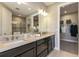 Double vanity bathroom with dark cabinets, quartz countertops and a walk-in shower at 29571 Velletri Ln, Wesley Chapel, FL 33545