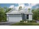 Two-story home with gray siding, two-car garage, and landscaping at 29571 Velletri Ln, Wesley Chapel, FL 33545