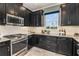 Modern kitchen with dark cabinetry and stainless steel appliances at 29571 Velletri Ln, Wesley Chapel, FL 33545