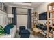 Study or home office with a light gray sofa, navy blue ottomans, and a desk at 29571 Velletri Ln, Wesley Chapel, FL 33545