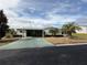 Single-wide manufactured home with carport and palm trees at 37729 Neukom Ave, Zephyrhills, FL 33541