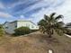 Side view of manufactured home showcasing landscaping at 37729 Neukom Ave, Zephyrhills, FL 33541